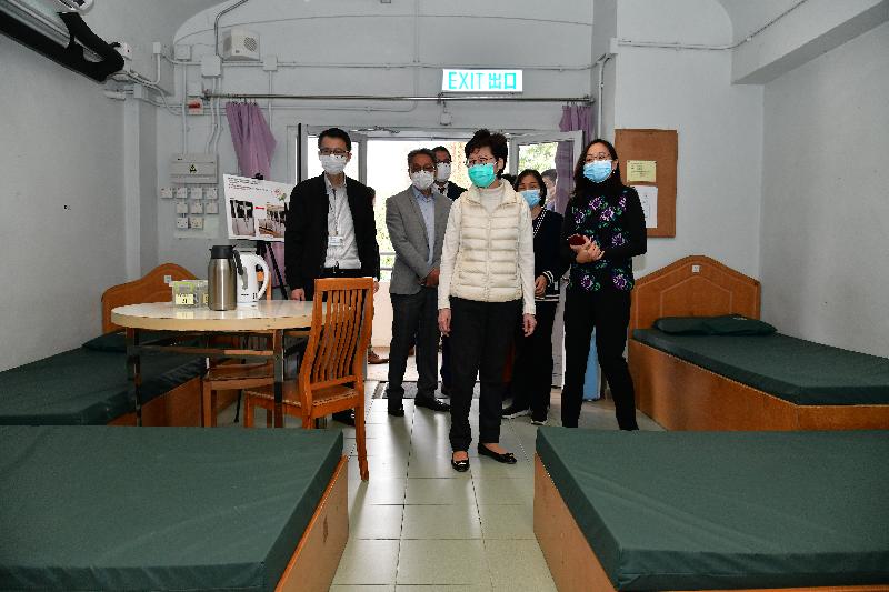 The Chief Executive, Mrs Carrie Lam (centre), today (March 25) visited the temporary accommodation at the Sai Kung Outdoor Recreation Centre to encourage the Government staff and volunteers who are managing the site and inspect the accommodation facilities as well as the quarantine units under construction. Photo shows Mrs Lam viewing a room in the temporary accommodation site. Looking on are the Secretary for Development, Mr Michael Wong (third left) and Deputy Director of Leisure and Cultural Services (Leisure Services), Ms Ida Lee (first right).
