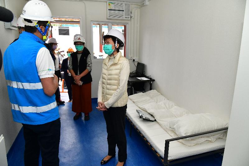 The Chief Executive, Mrs Carrie Lam (first right), today (March 25) visited the temporary accommodation at the Sai Kung Outdoor Recreation Centre to encourage the Government staff and volunteers who are managing the site and inspect the accommodation facilities as well as the quarantine units under construction. Photo shows Mrs Lam inspecting a temporary quarantine unit. Looking on is the Director of Architectural Services, Mrs Sylvia Lam (second right).