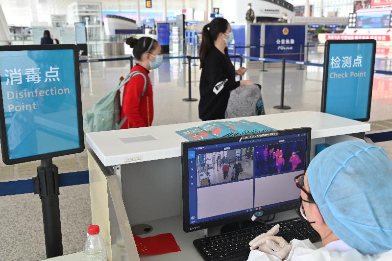 The Hong Kong Special Administrative Region Government today (March 25) arranged the second batch of chartered flights to bring back Hong Kong residents stranded in Hubei Province. Photo shows Hong Kong residents taking the second flight today undergoing infrared temperature checks before entering the Wuhan Tianhe International Airport.