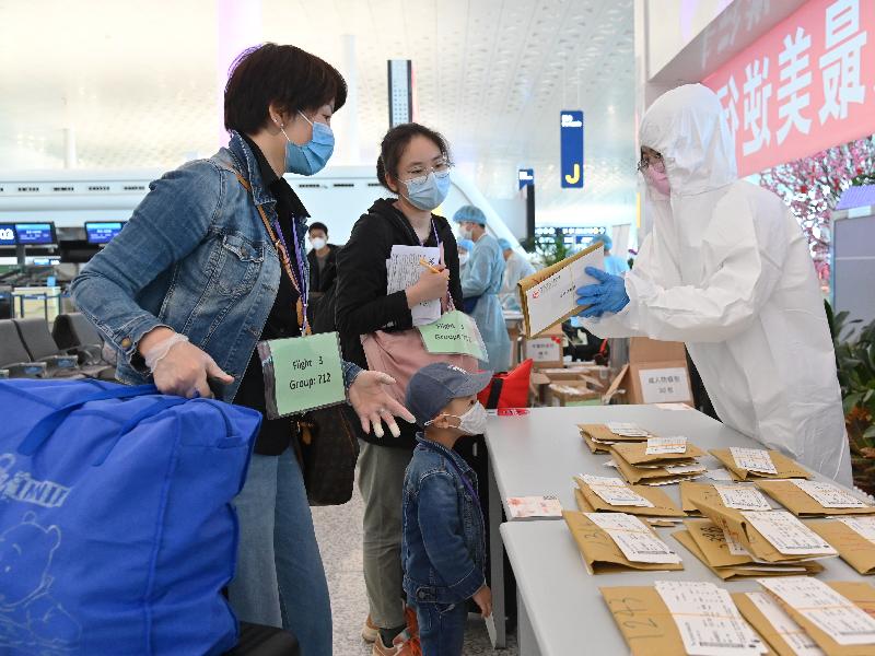 航空公司職員今日（三月二十六日）在武漢天河國際機場向乘搭專機的香港居民派發機票。
