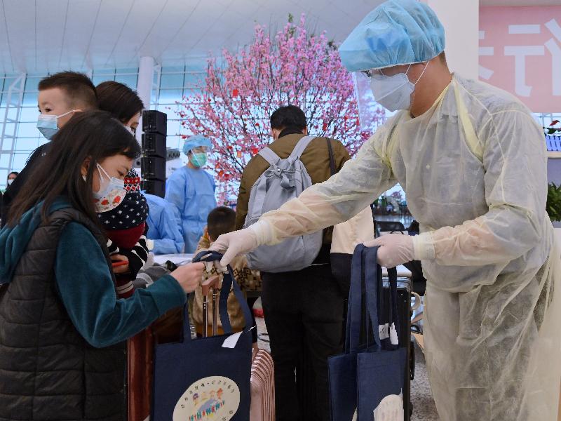 Immigration Department staff today (March 26) distributes gift packs at the Wuhan Tianhe International Airport to stranded Hong Kong residents who will take the chartered flight back to Hong Kong. The gift packs contain alcohol-based handrub, masks and health advice information.