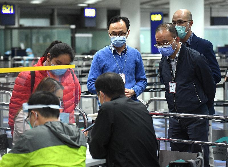 After arriving at Hong Kong from Wuhan today (March 26), the Secretary for Constitutional and Mainland Affairs, Mr Patrick Nip (second left), and the Director of Immigration, Mr Erick Tsang (second right), inspect the compulsory quarantine arrangements for the Hong Kong residents taking the chartered flights from Hubei to Hong Kong at the designated port health zone at Hong Kong International Airport.