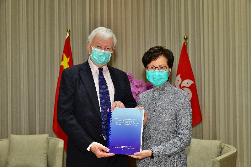The Chief Executive, Mrs Carrie Lam (right), receives the final report of the Commission of Inquiry into the Construction Works at and near the Hung Hom Station Extension under the Shatin to Central Link Project from the Commission's Chairman and Commissioner, Mr Michael Hartmann (left), today (March 27). 