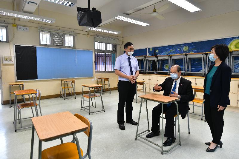 The Chief Secretary for Administration, Mr Matthew Cheung Kin-chung, today (April 22) visited Queen Elizabeth School to inspect the preparatory work and anti-epidemic precautionary measures of an examination centre for holding the Hong Kong Diploma of Secondary Education Examination. Photo shows Mr Cheung (centre), accompanied by the Under Secretary for Education, Dr Choi Yuk-lin (right), and the Principal of Queen Elizabeth School, Mr Eric Chan (left), visiting a classroom to understand the preparation required for an examination centre, including widening the distance between candidates' seats to 1.8 metres as far as possible.
