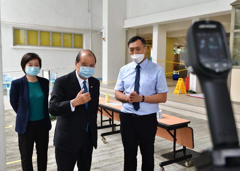 The Chief Secretary for Administration, Mr Matthew Cheung Kin-chung, today (April 22) visited Queen Elizabeth School to inspect the preparatory work and anti-epidemic precautionary measures of an examination centre for holding the Hong Kong Diploma of Secondary Education Examination. Photo shows Mr Cheung (centre), accompanied by the Under Secretary for Education, Dr Choi Yuk-lin (left), receiving a briefing by the Principal of Queen Elizabeth School, Mr Eric Chan (right), on the body temperature checking arrangements for all candidates and examination personnel before they enter examination centres.
