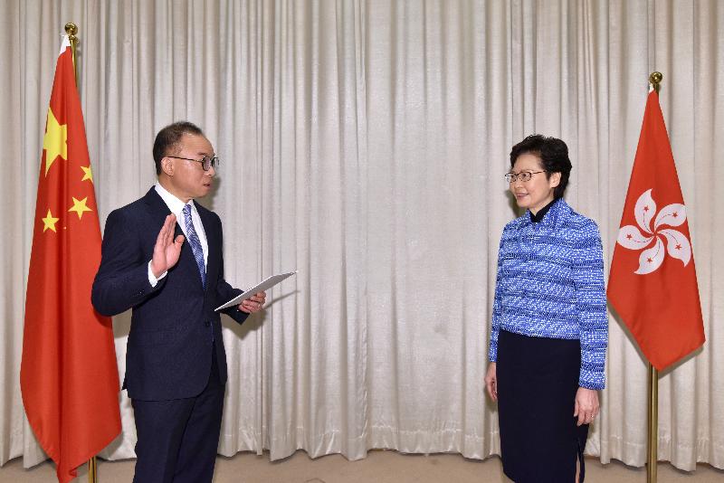 The new Secretary for Constitutional and Mainland Affairs, Mr Erick Tsang (left), takes the oath of office, witnessed by the Chief Executive, Mrs Carrie Lam (right), today (April 22).