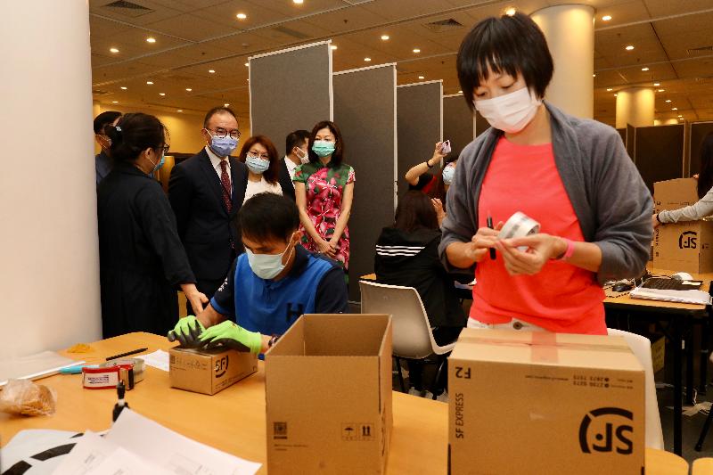 The Secretary for Constitutional and Mainland Affairs, Mr Erick Tsang Kwok-wai (back row, second left), visited the temporary operation centre for the special scheme introduced for delivering prescription medications to Hong Kong people in Guangdong and Fujian with urgent medication needs this afternoon (May 4). Photo shows volunteers packing prescription medications for shipment to the Mainland.