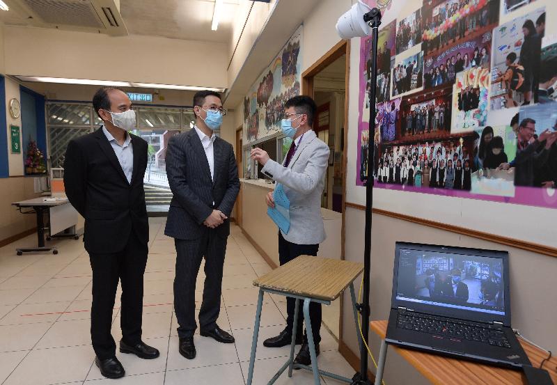 The Secretary for Education, Mr Kevin Yeung (centre), visited Lok Sin Tong Leung Kau Kui College today (May 22) to learn about the school’s preparation work for class resumption. Picture shows Mr Yeung (centre), accompanied by the Principal, Mr Lo Man-piu (left), listening to a teacher introducing the thermal imaging system used to check body temperature.