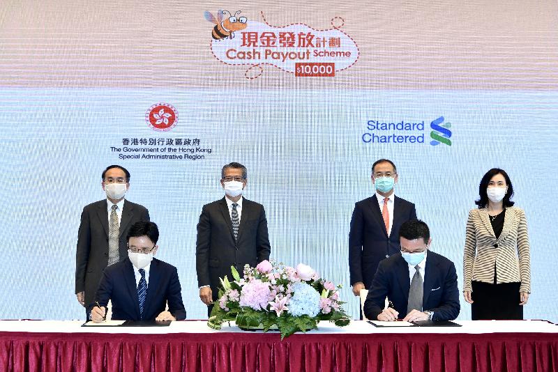 The Government signed service level agreements with representatives of 21 banks for the Cash Payout Scheme today (June 3). Photo shows the Director of Accounting Services, Mr Charlix Wong (front row, left), on behalf of the Government, signing the agreement with the Chief Operating Officer, Hong Kong Retail Banking of the Standard Chartered Bank (Hong Kong) (SCBHK), Mr William Ang (front row, right). The Financial Secretary, Mr Paul Chan (back row, second left); the Secretary for Financial Services and the Treasury, Mr Christopher Hui (back row, first left); the Chief Executive of the Hong Kong Monetary Authority, Mr Eddie Yue (back row, second right), and the Chief Executive Officer of the SCBHK, Ms Mary Huen (back row, first right), witnessed the signing ceremony. 
