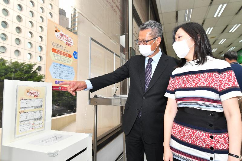 The Financial Secretary, Mr Paul Chan (left), accompanied by the Postmaster General, Miss Cathy Chu (right), toured the General Post Office of the Hongkong Post in Central today (June 26) to learn about the work of Hongkong Post in supporting the implementation of the Cash Payout Scheme.