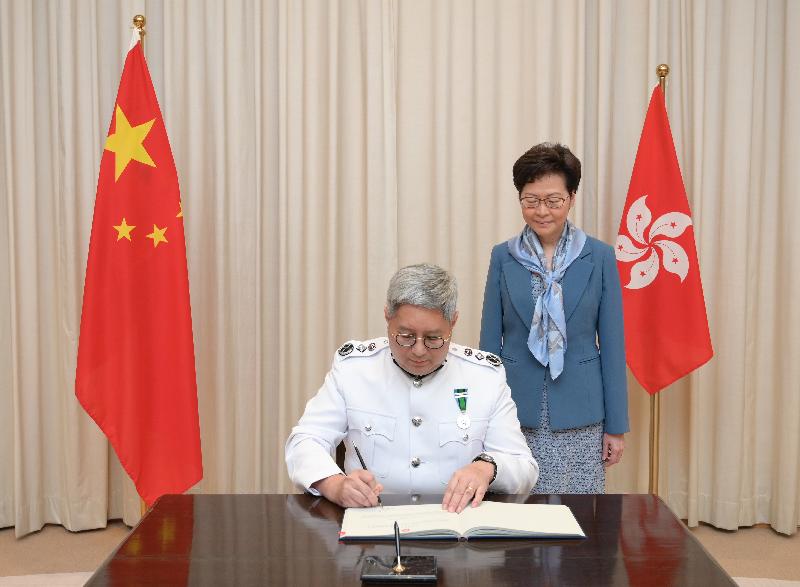 The new Director of Immigration, Mr Au Ka-wang (left), signs the oaths after his swearing-in today (July 2).

