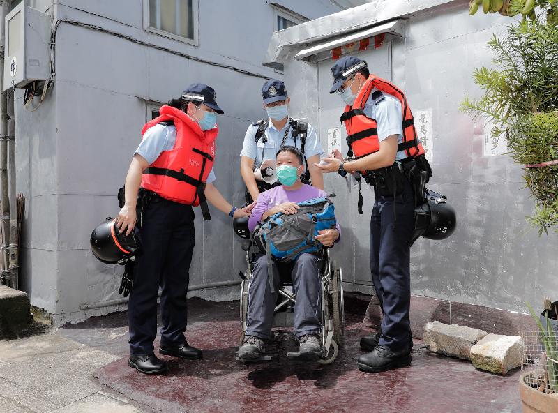 離島民政事務處今日（七月六日）在大澳舉行跨部門水浸模擬救援及疏散演練。為考驗救援隊伍的能力，聯合演練安排實時個案。圖示居民模擬被困及致電求助後，警務處派員拯救。