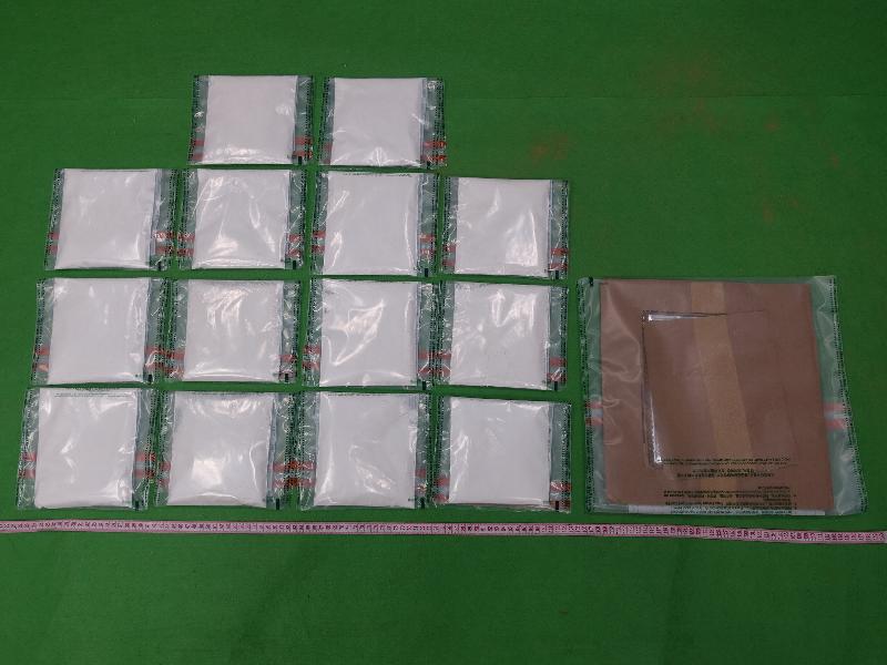 香港海關昨日（七月九日）在香港國際機場檢獲約二點一公斤懷疑可卡因，估計市值約二百一十萬元。圖示檢獲的懷疑可卡因及其中一塊用作收藏毒品的卡紙。