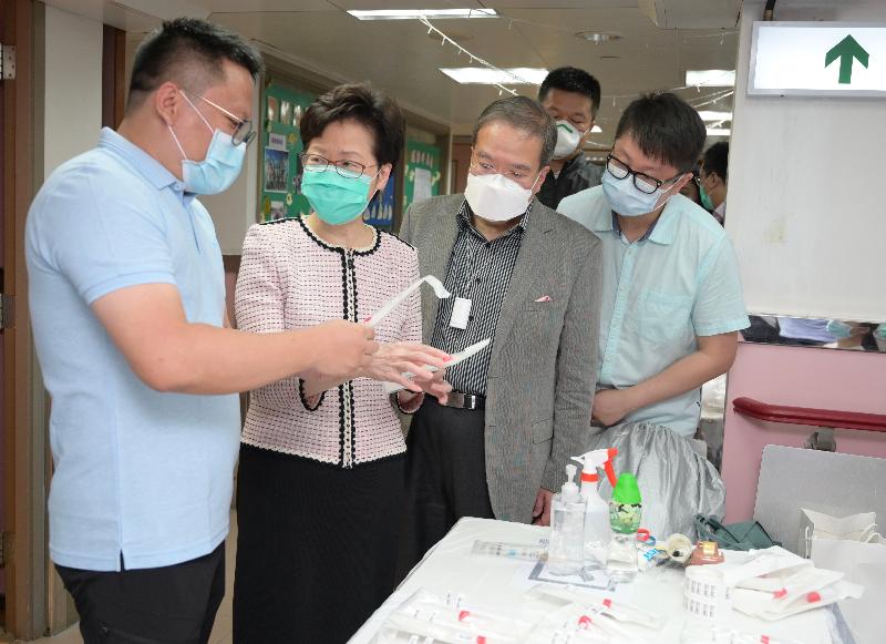 The Chief Executive, Mrs Carrie Lam, visited a residential care home for the elderly in Tsz Wan Shan today (July 14) to inspect COVID-19 tests arranged by the Government for staff members working at the residential care homes for the elderly. Photo shows Mrs Lam (second left) being briefed by BGI Genomics General Manager, Mr Yin Ye (first left) on the tools used for collecting throat swab samples for COVID-19 test. Looking on is Director of Sunrise Diagnostic Centre Limited, Professor Anthony Wu (third left).