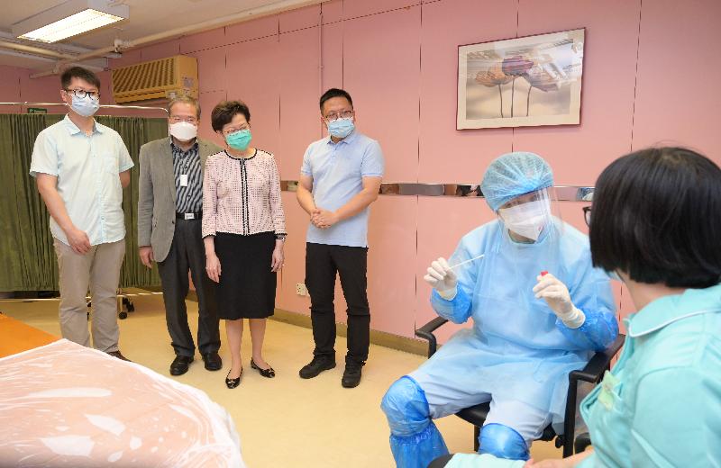 The Chief Executive, Mrs Carrie Lam, visited a residential care home for the elderly in Tsz Wan Shan today (July 14) to inspect COVID-19 tests arranged by the Government for staff members working at the residential care homes for the elderly. Photo shows Mrs Lam (third left) observing the simulation of the collection of throat swab sample for COVID-19 test by the testing staff.