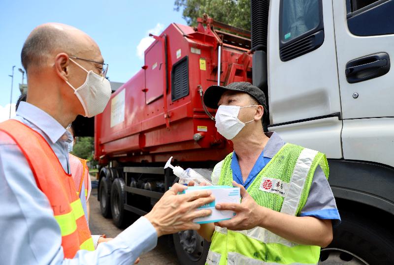 The Secretary for the Environment, Mr Wong Kam-sing, today (July 23) visited the North Lantau Transfer Station (NLTS) to inspect the distribution of face masks by the Environmental Protection Department to drivers of refuse collection vehicles who use the NLTS's refuse transfer service as well as the operation of the station. Photo shows Mr Wong (left) distributing face masks and a hand sanitiser to a refuse collection vehicle driver.