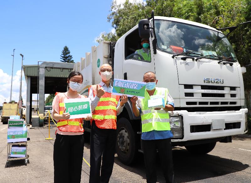 The Secretary for the Environment, Mr Wong Kam-sing, today (July 23) visited the North Lantau Transfer Station (NLTS) to inspect the distribution of face masks by the Environmental Protection Department to drivers of refuse collection vehicles who use the NLTS’s refuse transfer service as well as the operation of the station. Photo shows Mr Wong (centre) distributing face masks to the refuse collection vehicle drivers and expressing thanks to them for standing ready to fight the epidemic. 