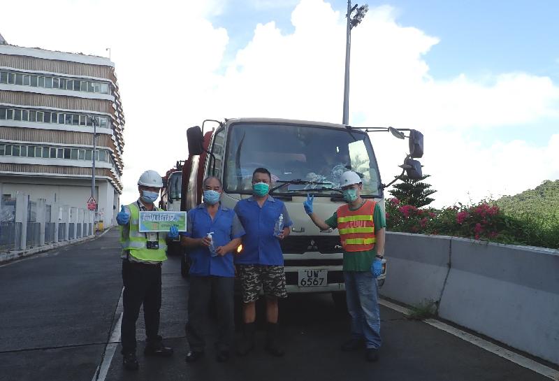 The Environmental Protection Department (EPD) today (August 14) distributed disinfectant hand sanitisers to drivers of refuse collection vehicles using the services at refuse transfer stations and landfills to support the work of frontline personnel and thank them for standing ready to fight the epidemic. Photo shows refuse collection vehicle drivers receiving disinfectant hand sanitisers from EPD staff members at a refuse transfer station.