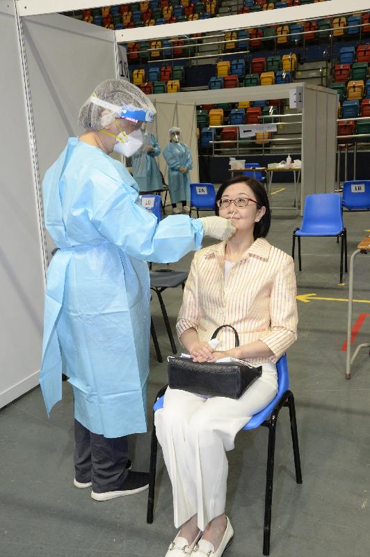 The Director of Health, Dr Constance Chan, today (September 1) inspected the community testing centre set up at Queen Elizabeth Stadium in Wan Chai to learn about its operation on the first day of the Universal Community Testing Programme. Photo shows Dr Chan (right) having her samples taken on-site for testing.