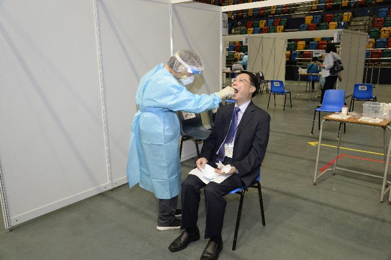 The Consultant in-charge, Dental Services of the Department of Health, Dr Wiley Lam (right), takes part in the Universal Community Testing Programme in the community testing centre at Queen Elizabeth Stadium today (September 1).

