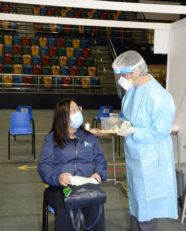 The Principal Nursing Officer of the Department of Health, Dr Mary Foong (left), today (September 1) is briefed by a colleague on-site on the points to note before having her specimens collected in the community testing centre at Queen Elizabeth Stadium.