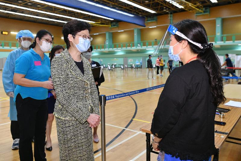 The Chief Executive, Mrs Carrie Lam (third left), today (September 7) visited two community testing centres at Kowloon City Sports Centre and To Kwa Wan Sports Centre to learn more about their operation as the Universal Community Testing Programme enters its second week and to thank the healthcare workers and staff members for their dedication and hard work. Photo shows Mrs Lam chatting with a staff member of the community testing centre at To Kwa Wan Sports Centre.