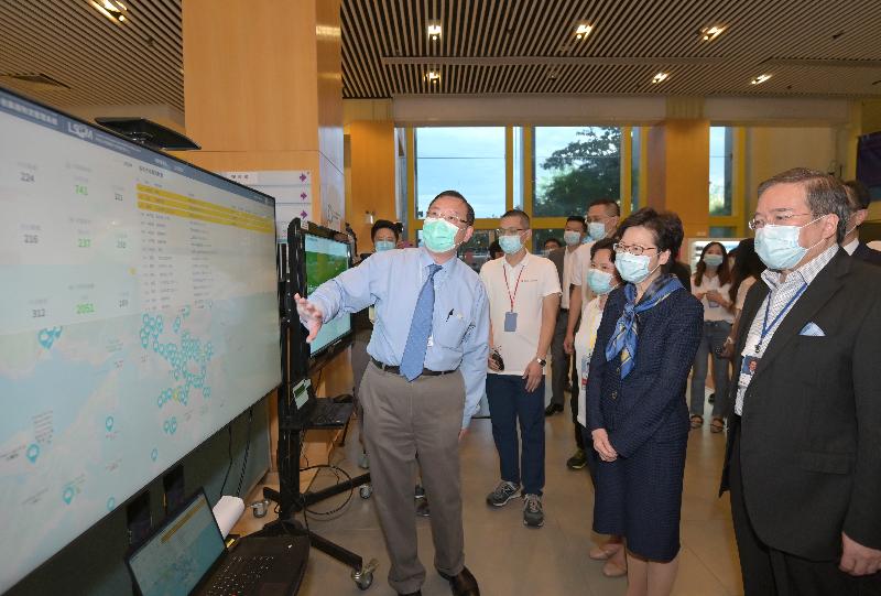 The Chief Executive, Mrs Carrie Lam, visited the temporary air-inflated laboratories at Sun Yat Sen Memorial Park Sports Centre in the Central and Western District this evening (September 9) to learn more about their operation and to give encouragement to staff members. Picture shows Mrs Lam (second right) receiving a briefing by the Chief Executive Officer of the Logistics and Supply Chain MultiTech R&D Centre, Mr Simon Wong (first left), on the technologies applied in streamlining logistical arrangements to ensure timely and secure delivery of specimens from community testing centres to the laboratory everyday.