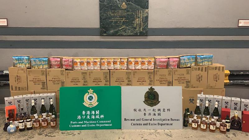 Hong Kong Customs detected three suspected cases of smuggling illicit liquor through seaborne containers between late May and early September. A total of about 350 litres in 550 bottles of suspected duty-not-paid liquor, about 3 240 litres in 3 730 bottles of suspected smuggled sake, about 130 litres in 380 cans of suspected smuggled beer and a batch of suspected smuggled assorted goods were seized. The total estimated market value was about $1.2 million with a duty potential of about $150,000. Photo shows some of the liquor, sake and smuggled assorted goods involved in the cases.