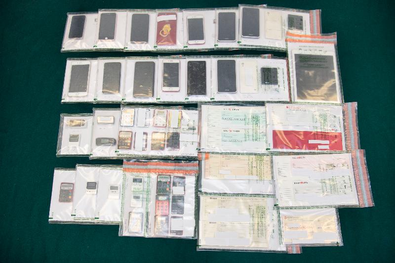 Hong Kong Customs mounted an operation codenamed "Shadow Hunter" in September and successfully smashed a large-scale money laundering syndicate involving a family of five and a local money changer. The amount involved in the case was over $3 billion, which is the largest ever among similar cases handled by Customs. Photo shows some of the mobile phones, banking security authentication tokens and signed cheque books seized by Customs officers during the operation.