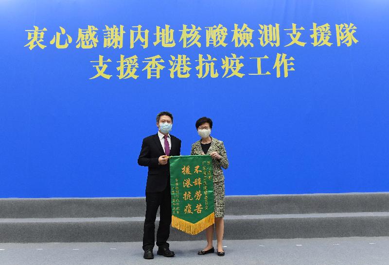 The Hong Kong Special Administrative Region Government today (September 15) held a farewell ceremony for the Mainland nucleic acid test support team. Photo shows the Chief Executive, Mrs Carrie Lam (right), presenting a memorial flag to the leader of the support team (Guangdong), Mr Yu Dewen.