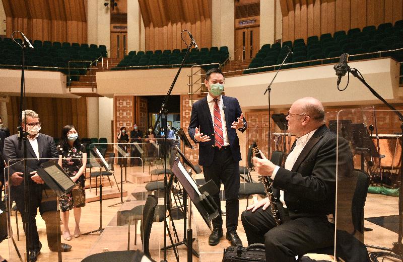 The Secretary for Home Affairs, Mr Caspar Tsui, attended a rehearsal of the Hong Kong Philharmonic Orchestra in the Concert Hall of the Hong Kong Cultural Centre this evening (September 18). Photo shows Mr Tsui (centre) learning about how the rehearsal was conducted in adherence to the anti-epidemic measures in the venue. Players were seated to keep at least 1.5 metres apart. Partitions were also placed to separate the wind instrument players. 
