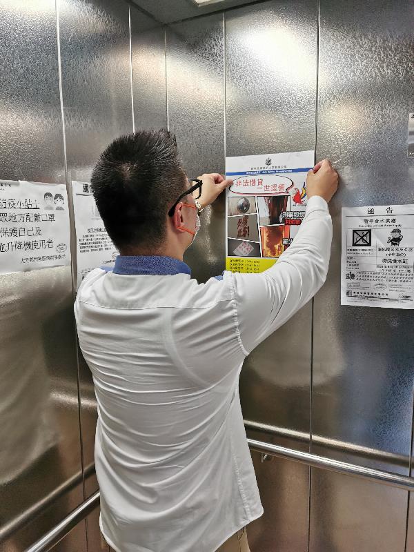 Police New Territories North Region Crime Prevention Office held a publicity campaign to combat illegal debt collection activities. Photo shows a police officer putting up a poster at an elevator at a housing estate, appealing the residents to report illegal debt collection activities.