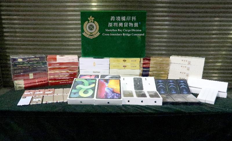 香港海關昨日（十月二十八日）在深圳灣管制站檢獲一批懷疑走私智能電子產品及約一萬九千支懷疑私煙，估計市值約二百一十萬元。圖示部分檢獲的懷疑走私物品。