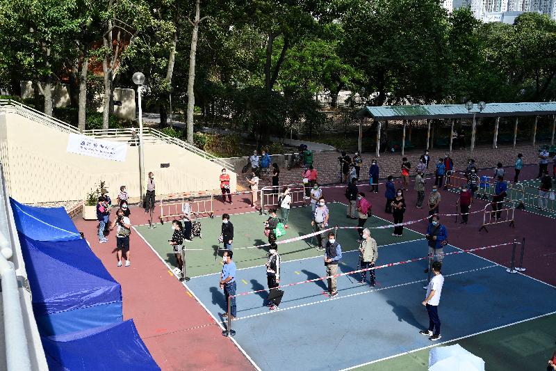 In order to identify cases in the community as early as possible to help cut transmission chains, the Government has arranged a testing agency to provide free specimen collection and COVID-19 testing services through mobile specimen collection stations in Tai Po for three consecutive days starting today (November 9). Photo shows members of the public responding positively as they line up at the volleyball court next to Kwong Wai House of Kwong Fuk Estate for their specimen collection.