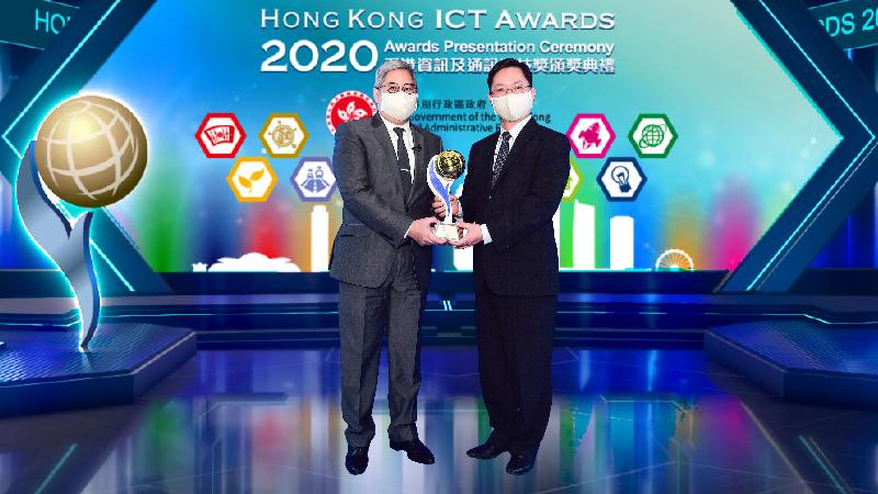 創新及科技局局長薛永恒（右）在今日（十二月四日）播放的2020年香港資訊及通訊科技獎頒獎典禮向入境事務處處長區嘉宏（左）頒發商業方案大獎。
