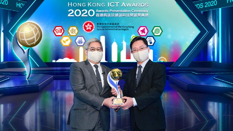 入境事務處處長區嘉宏（左）從創新及科技局局長薛永恒（右）接過「2020香港資訊及通訊科技獎：商業方案大獎」。