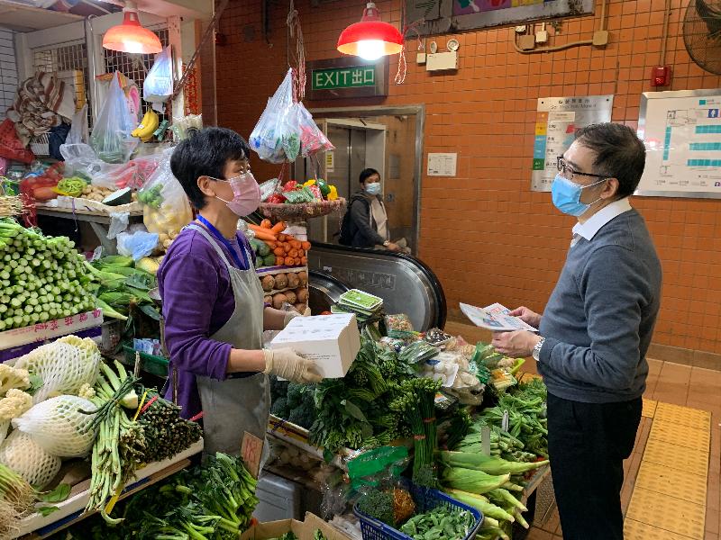 The Assistant Director of Food and Environmental Hygiene, Mr Gabriel Tsang (right), visited Sai Ying Pun Market yesterday (December 15) to distribute masks and leaflets to market tenants, reminding them to adopt various anti-epidemic measures and comply with anti-epidemic regulations.