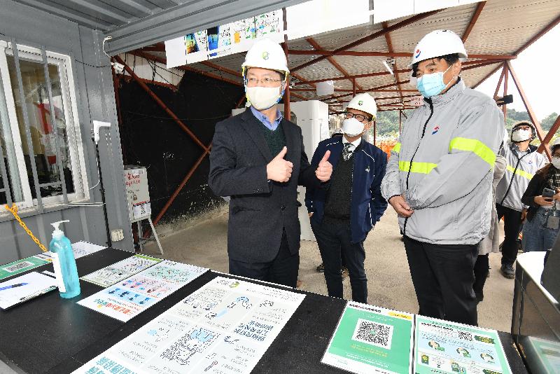 The Secretary for Innovation and Technology, Mr Alfred Sit (left), thanks the Executive Director of the Construction Industry Council, Mr Albert Cheng (centre), for engaging the construction industry to fight the virus together and supporting the "LeaveHomeSafe" mobile app at the construction site of Montego Bay in Yau Tong today (December 17). 