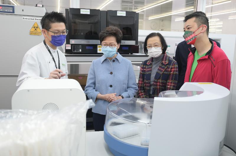 The Chief Executive, Mrs Carrie Lam (second left), today (December 25) visited the five private laboratories which help the Government provide COVID-19 testing services to learn more about their back of house operations and extend her holiday greetings to the staff members on duty. Photo shows Mrs Lam visiting the laboratory of Prenetics. Looking on is the Secretary for Food and Health, Professor Sophia Chan (third left).
