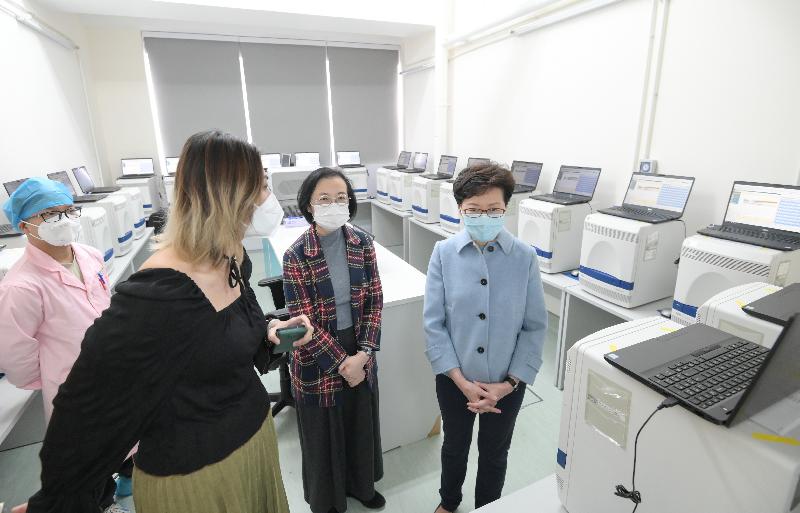 The Chief Executive, Mrs Carrie Lam (first right), today (December 25) visited the five private laboratories which help the Government provide COVID-19 testing services to learn more about their back of house operations and extend her holiday greetings to the staff members on duty. Photo shows Mrs Lam visiting the laboratory of KingMed Diagnostics (Hong Kong) Limited. Looking on is the Secretary for Food and Health, Professor Sophia Chan (second right).
