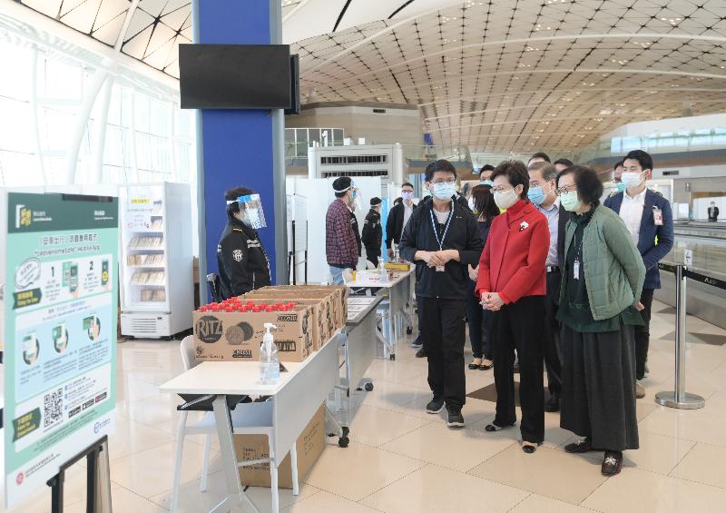 The Chief Executive, Mrs Carrie Lam (front row, centre), today (December 26) visited the Midfield Concourse of the Hong Kong International Airport to inspect the implementation and enforcement of quarantine measures for inbound travellers by various departments.