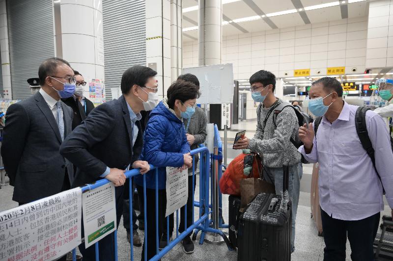 The Chief Executive, Mrs Carrie Lam, visited the Shenzhen Bay Control Point and Hong Kong-Zhuhai-Macao Bridge Control Point today (December 27) to inspect the implementation of the Return2hk – Travel Scheme (Return2hk Scheme) for Hong Kong Residents returning from Guangdong Province or Macao without being subject to quarantine. Photo shows Mrs Lam (third left) chatting with a father and his son returning to Hong Kong via Return2hk Scheme at the Shenzhen Bay Control Point. Looking on are the Secretary for Security, Mr John Lee (second left) and the Secretary for Constitutional and Mainland Affairs, Mr Erick Tsang Kwok-wai (first left).