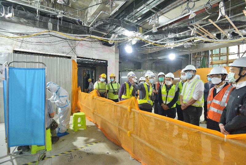 The Secretary for Development, Mr Michael Wong, visited a construction site at Muk Yuen Street in Kai Tak today (January 28) to learn about the testing arrangement for construction workers under the Construction Industry COVID-19 Testing Service Scheme. Picture shows Mr Wong (front row, third right) viewing the testing arrangement for construction workers.