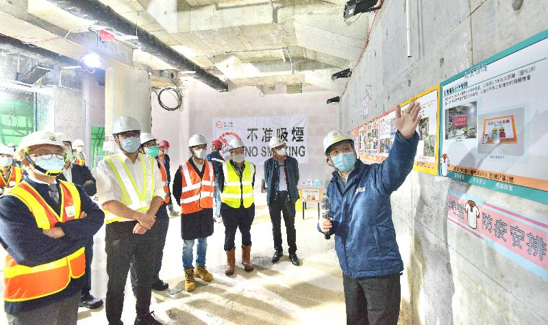 The Secretary for Development, Mr Michael Wong, visited a construction site at Muk Yuen Street in Kai Tak today (January 28) to learn about the testing arrangement for construction workers under the Construction Industry COVID-19 Testing Service Scheme. Picture shows Mr Wong (second left); the Chairman of the Construction Industry Council (CIC), Mr Chan Ka-kui (first left); and the Executive Director of the CIC, Mr Albert Cheng (second right), viewing the preventive measures adopted at the site.
