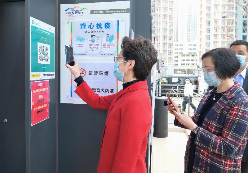 The Chief Executive, Mrs Carrie Lam, today (February 8) visited the Skylight Market in Tin Shui Wai. Photo shows Mrs Lam (left) and the Secretary for Food and Health, Professor Sophia Chan (right), scanning the QR code of the "LeaveHomeSafe" mobile app before entering the market.