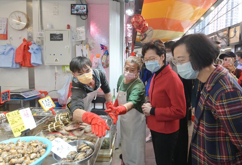 The Chief Executive, Mrs Carrie Lam, today (February 8) visited the Skylight Market in Tin Shui Wai. Photo shows Mrs Lam (second right) learning about the business of a seafood stall in the market. Looking on is the Secretary for Food and Health, Professor Sophia Chan (first right).