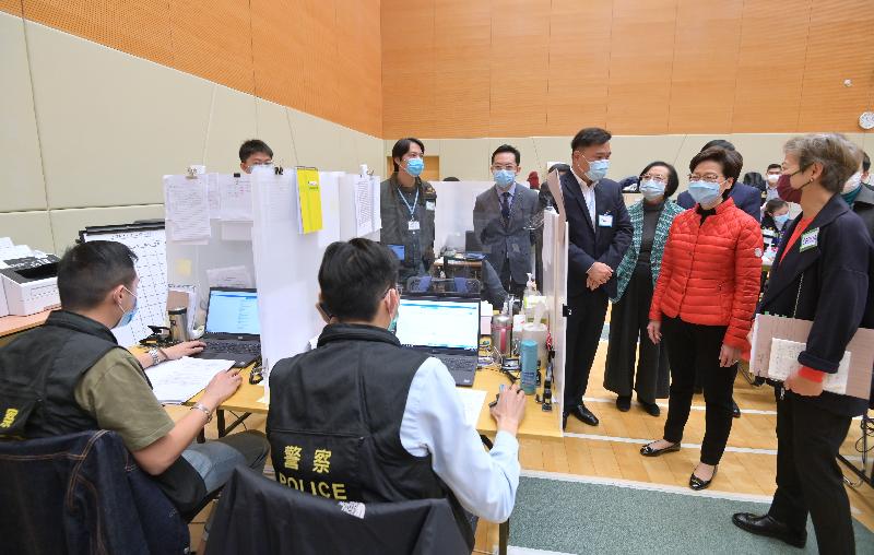 The Chief Executive, Mrs Carrie Lam, today (February 11) visited the Contact Tracing Office at Kai Tak Community Hall to learn more about the work of tracing the contacts of COVID-19 confirmed cases. Photo shows Mrs Lam (second right) chatting with police officers at the Contact Tracing Office. Looking on is the Secretary for Food and Health, Professor Sophia Chan (third right).