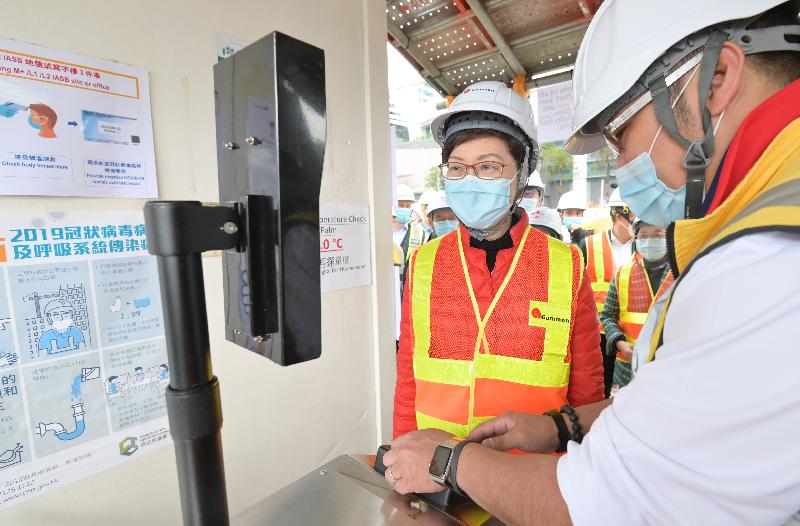 The Chief Executive, Mrs Carrie Lam, today (February 11) inspected the anti-epidemic measures at the construction site of the M+ museum in West Kowloon Cultural District. Photo shows Mrs Lam (left) checking her body temperature before entering the construction site.