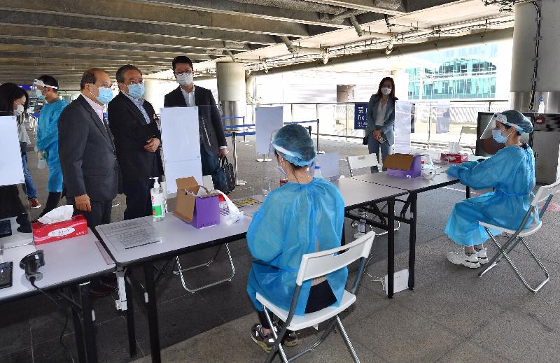 政务司司长张建宗今日（二月十三日）到访香港国际机场。图示张建宗（左一）参观专为机场员工而设的专属检测中心，了解中心的运作情况。