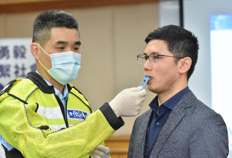 警方将采用快速口腔液测试打击毒后驾驶。图为交通总区人员今日（二月十八日）于记者会上示范操作快速口腔液测试仪器。